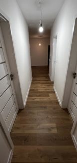 Na chodbe sa krásne dopĺňajú biele interiérové dvere s plávajúcou podlahou so vzhľadom dreva. Páči s vám?